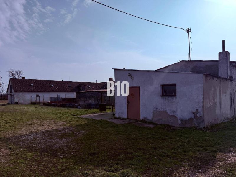 Výrobní prostory v exteriéru ve městě Turá s jednoduchými stavbami a travnatou plochou.
