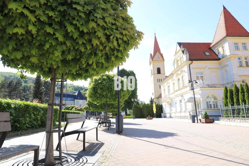 Náměstí v Trenčianských Teplicích s lavičkami, stromy a historickou architekturou, Pozemky - bydlení.