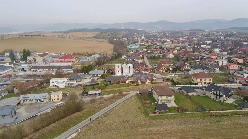Letecký pohled na obytnou oblast v Rosině s domy a zelení. Pozemky - bydlení.