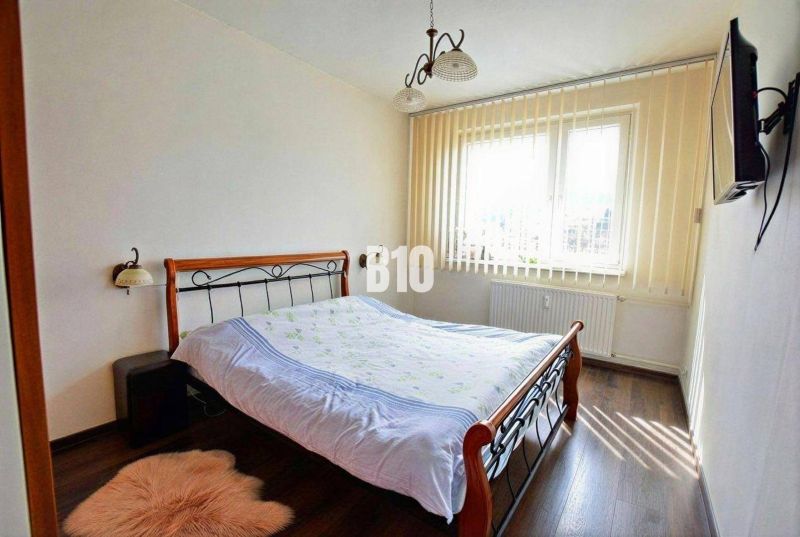 Ložnice s manželskou postelí a podlahou s dřevěným dekorem, 3pokojový byt.