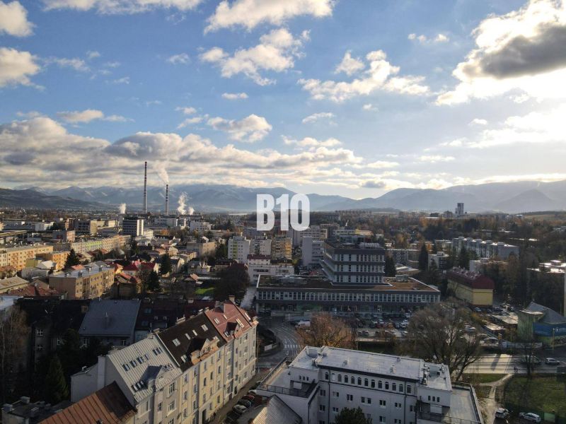 Město Žilina s panoramatem, bytové domy a průmyslová zóna v popředí.