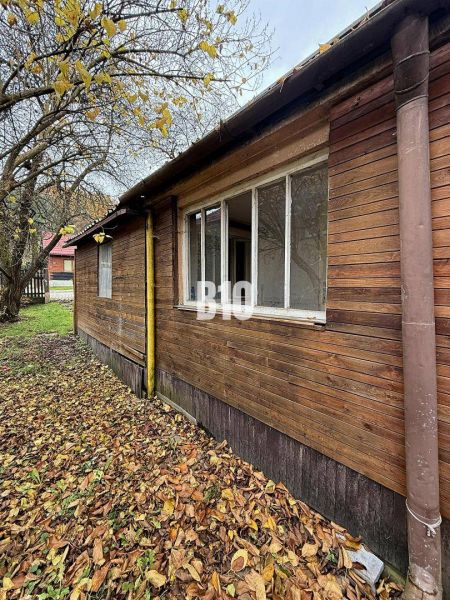 Rodinný dům v Kotešové se starší dřevěnou fasádou, obklopený podzimními listy a stromy.