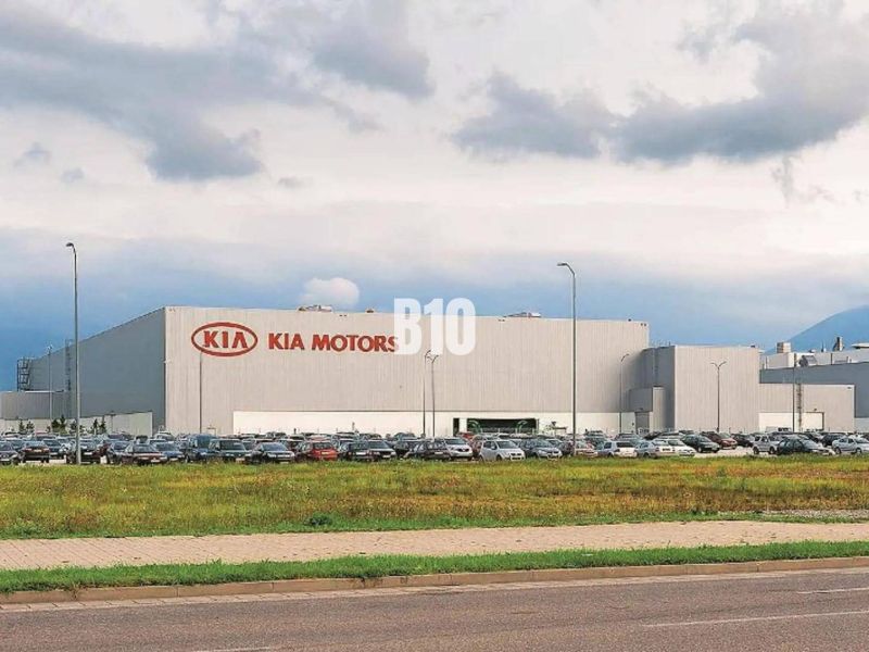 Budova Kia Motors v Žilině, pozemky - komerční se zaparkovanými auty a travnatou plochou.