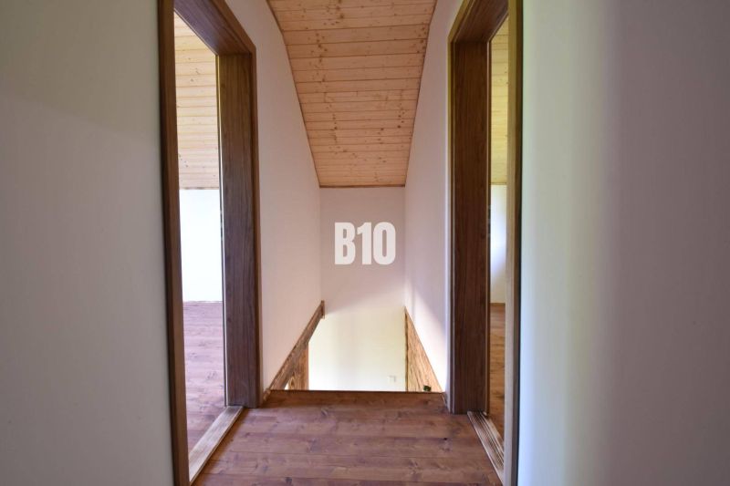 Dřevěné podkroví s chodbou v chatě, s přírodním stropem a podlahou.