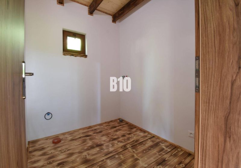 Dřevěná podlaha a dveře v interiéru chaty se světlíkem.