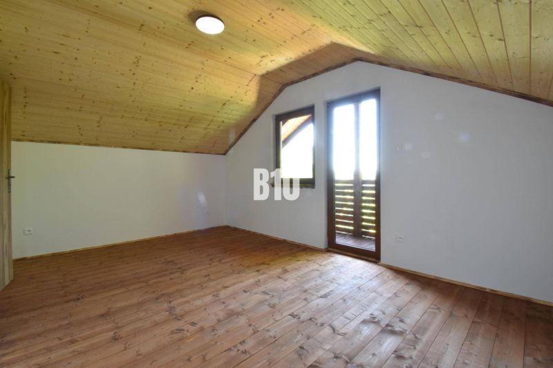 Podkrovní pokoj s dřevěným obložením a podlahou v Chatě u Bytče.
