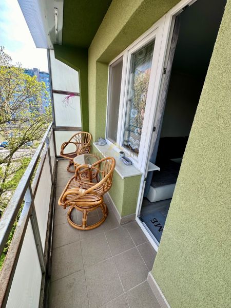 Balkon se dvěma ratanovými křesly a stolkem, výhled na zeleň, 3pokojový byt.