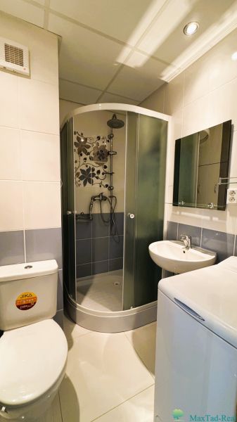 Koupelna v 1-pokojovém bytě s WC, sprchovým koutem a umyvadlem.