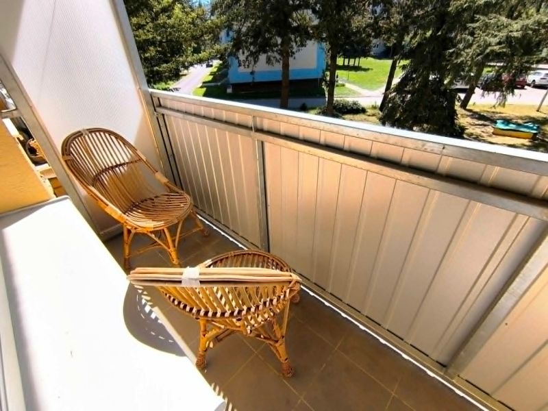 Balkon 1-pokojového bytu na Malé okružní v Partizánském s ratanovým posezením.