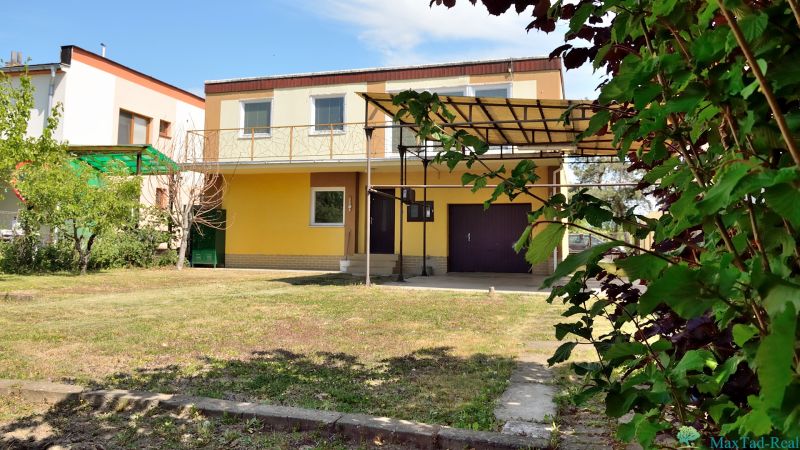 Žlutý rodinný dům s garáží a terasou na ulici Nábřeží J. M. Hurbana v Michalovcích.