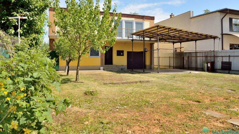 Rodinný dům na ulici Nábřeží J. M. Hurbana v Michalovcích s trávníkem a přístřeškem.