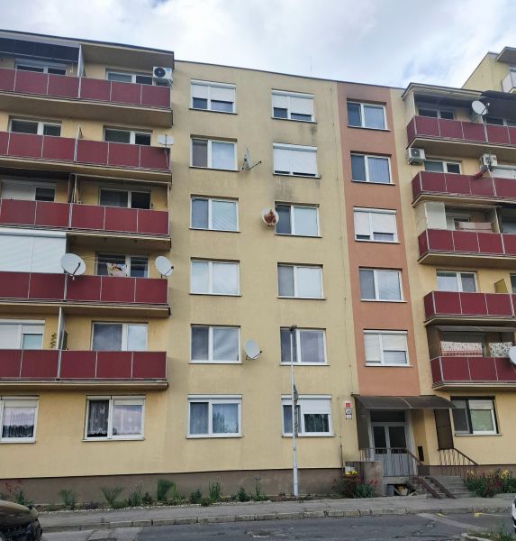 Bytový dům na ulici Nábrežná v Nových Zámcích s červenými balkóny.