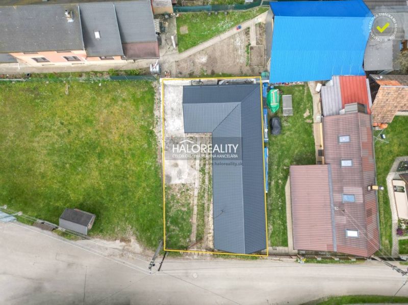Letecký pohled na rodinný dům ve Stupném obklopený travnatým pozemkem a sousedními budovami.