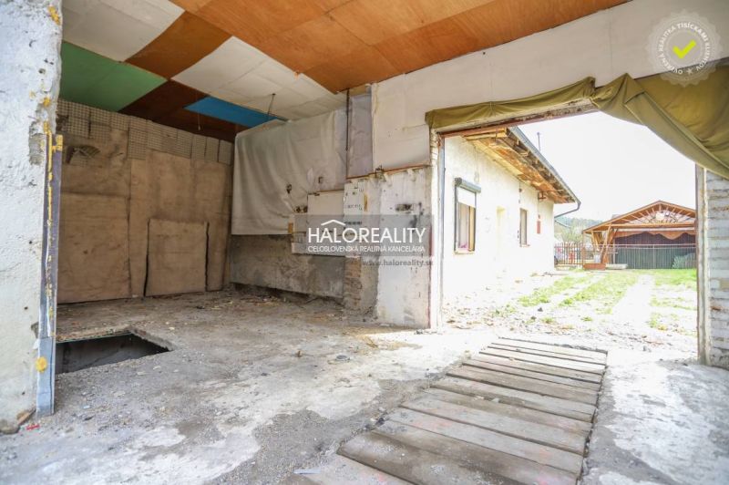 Pohled na garáž v rodinném domě ve Stupném s provizorní dřevěnou podlahou.