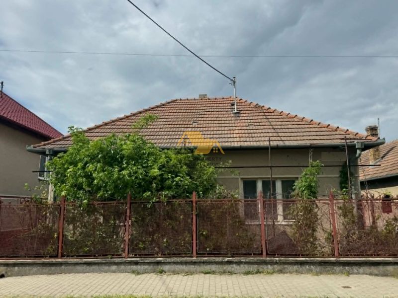 Rodinný dům v Bánově na ulici Bánov s cihlovou střechou a plotem.