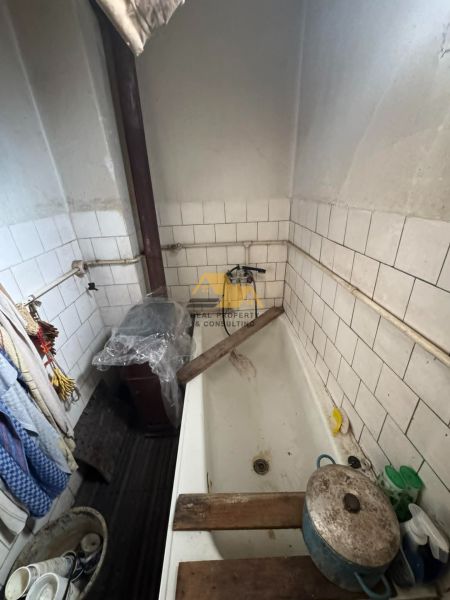 Malá koupelna v rodinném domě s bílými obkladačkami a vanou.