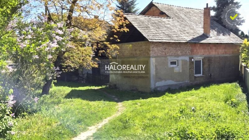 Rodinný dům v Poltáři obklopený zelenou zahradou a rozkvetlými stromy.