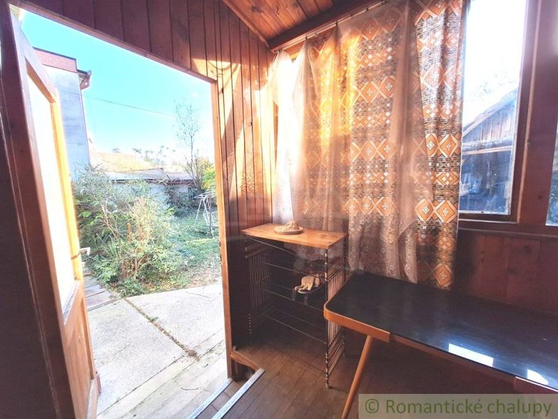 Interiér rodinného domu s podlahou s dřevěným dekorem a výhledem do zahrady.