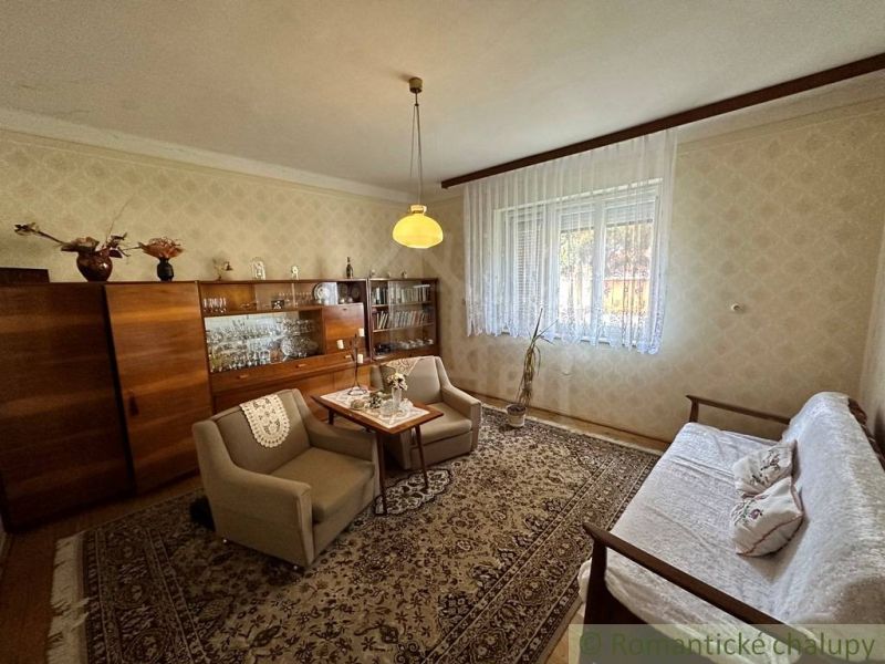 Obývací pokoj s retro nábytkem a podlahou s dřevěným dekorem v rodinném domě.