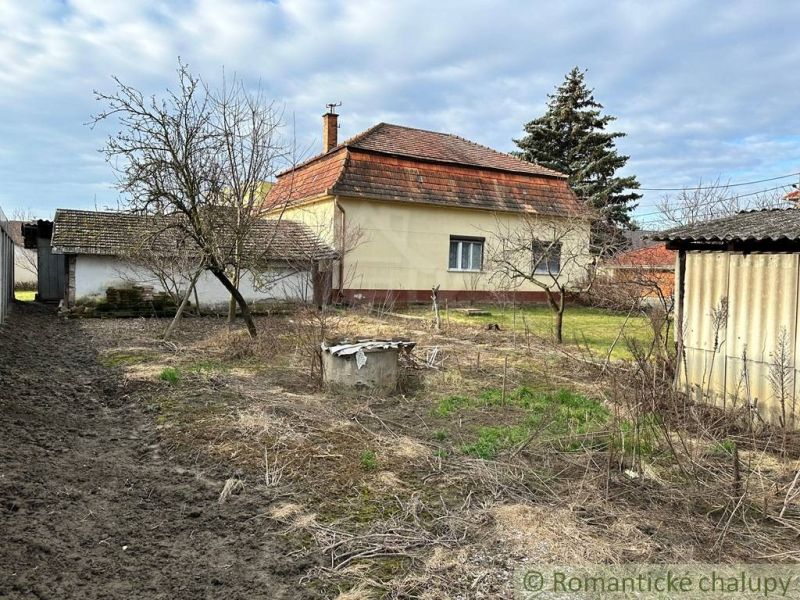 Rodinný dům v Kolárově s prostornou zahradou, stromy a vedlejší budovou.