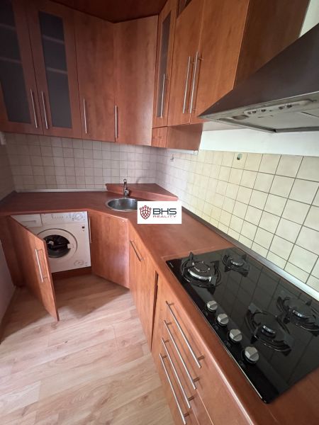 Kuchyně v 2pokojovém bytě s podlahou s dřevěným dekorem a vestavěnými spotřebiči.