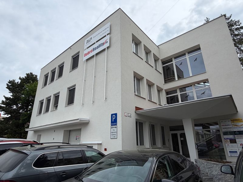 Budova kanceláří na Dlouhé ulici v Prievidzi se zaparkovanými auty.