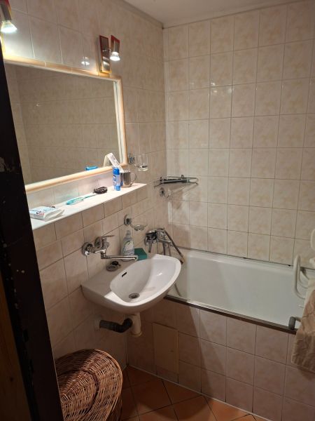 Koupelna s vanou, umyvadlem a zrcadlem v 2-pokojovém bytě.