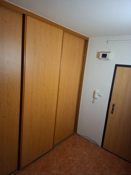 Vestavěná skříň v předsíni s podlahou s dřevěným dekorem v 2pokojovém bytě.