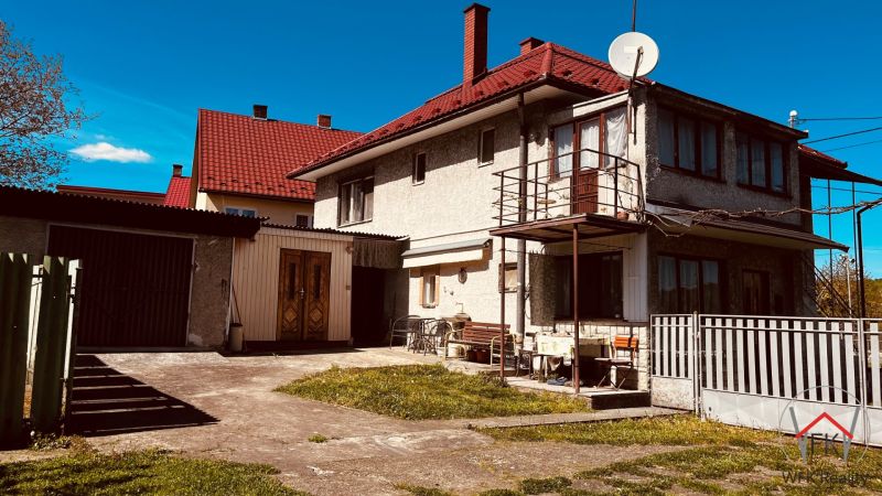 Rodinný dům v Nové Kelči, Nová Kelča s dvorem, garáží a balkonem pod modrou oblohou.