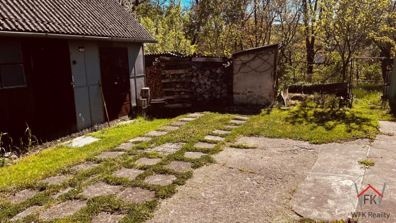 Dvůr u rodinného domu v Nové Kelči s garáží a krbem na sklad dřeva.