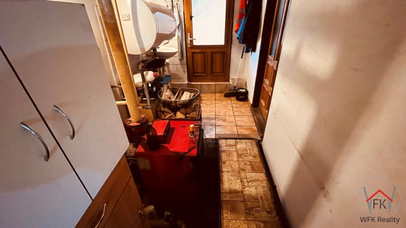 Koupelna s bojlerem a technickým zařízením v rodinném domě, útulný prostor na uskladnění.