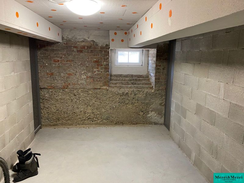 Sklepní místnost s betonovými stěnami a oknem v 2-pokojovém bytě.
