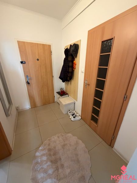Interiér 2-pokojového bytu se šatnou, dlažbou a pohodlným kobercem.