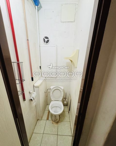Interiér s keramickou dlažbou obsahuje WC s větracím otvorem a čisticími potřebami.