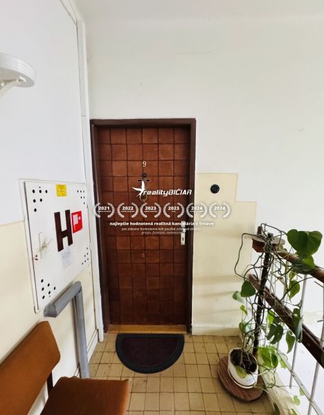 Vstupní dveře 3pokojového bytu s číslem devět, vedoucí na schodiště.