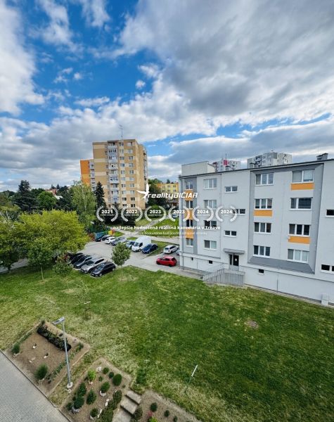 Pohled na obytné budovy a parkoviště na ulici Za poštou v Hlohovci.