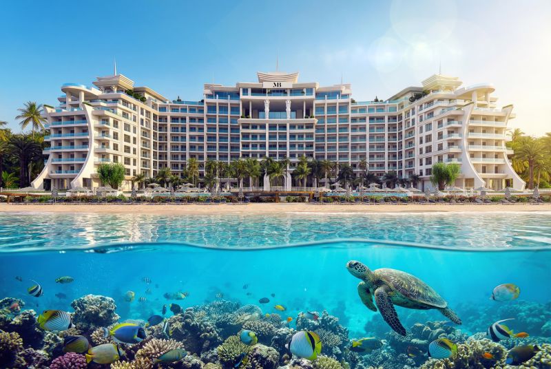 Hotel na pláži v Paje, v popředí želva a pestrobarevné ryby.