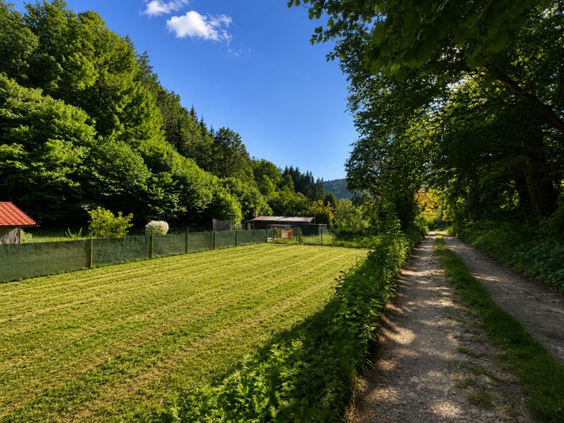 Pozemek na bydlení v Kostiviarské, Banská Bystrica, vedle Kostiviarské cesty, obklopený zelení.