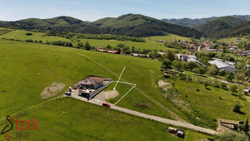 Pozemky na bydlení v Lietavské Svinnej-Babkově uprostřed zelené krajiny s vesnicí v pozadí.