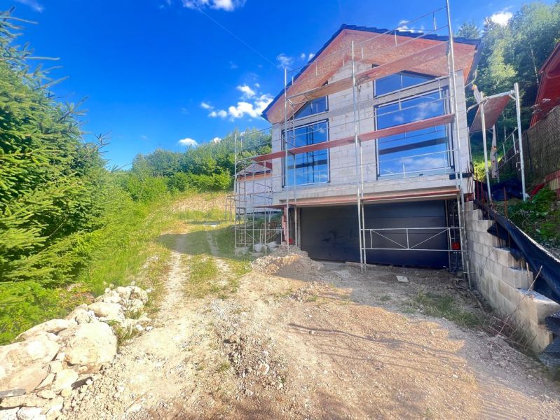 Rodinný dům v rekonstrukci s lešením, obklopený přírodou v Badíně, okres Banská Bystrica, Slovensko.
