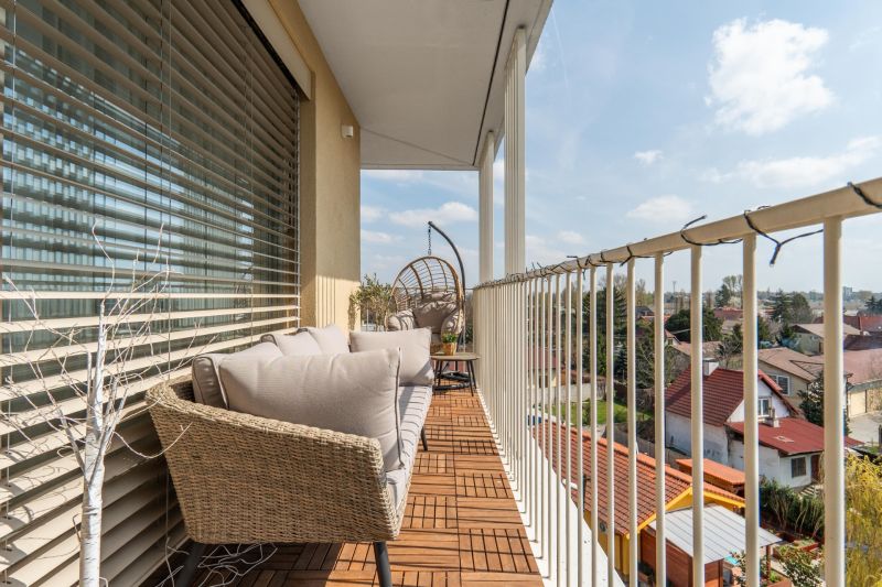 Balkon 3-pokojového bytu v Bratislavě - Ružinově s venkovním posezením a dřevěným dekorem.