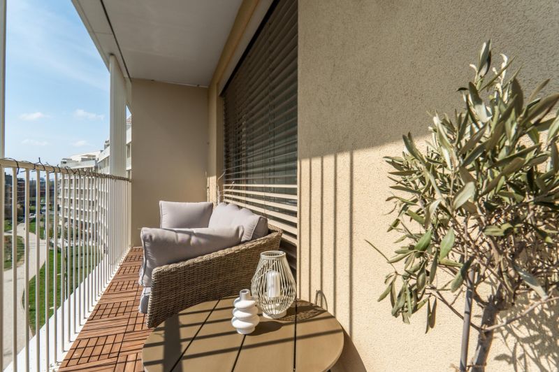 Balkon v 3-pokojovém bytě s pohodlným sezením, výhledem a dekoracemi.