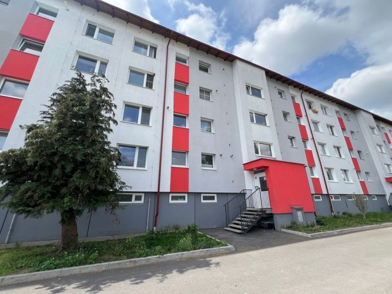 Bytový dům na ulici Za Nožiarňou, Slovenská Ľupča, s výraznými červenými panely.