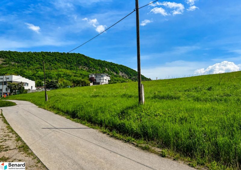Kopcovitá krajina u Fintic s pozemky na bydlení a venkovem v pozadí.