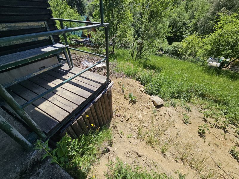 Chata v Budatíně s terasou a výhledem na zeleň a svah.