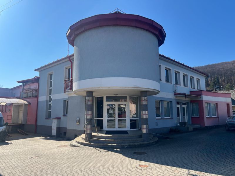 Budova s obloukovým vchodem v Kremničce, Banská Bystrica, sloužící pro sklady a haly.