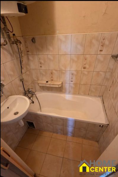 Koupelna s vanou a dlažbou v 3-pokojovém bytě, jednoduchý design.