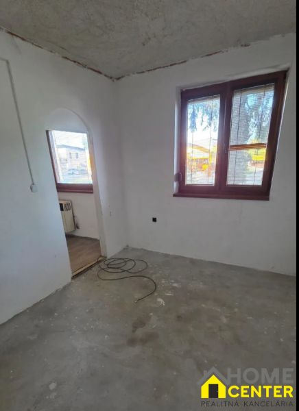 Nevyhotovená stěna a okna v pokoji 3pokojového bytu s možnou renovací.