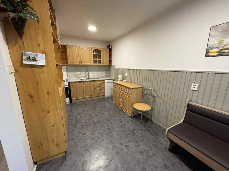 Kuchyně ve 4-pokojovém bytě s dřevěnými skříňkami a podlahou s dřevěným dekorem.