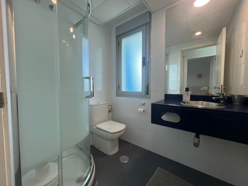 Koupelna s toaletou, sprchovým koutem a umyvadlem v rekreačním apartmánu.